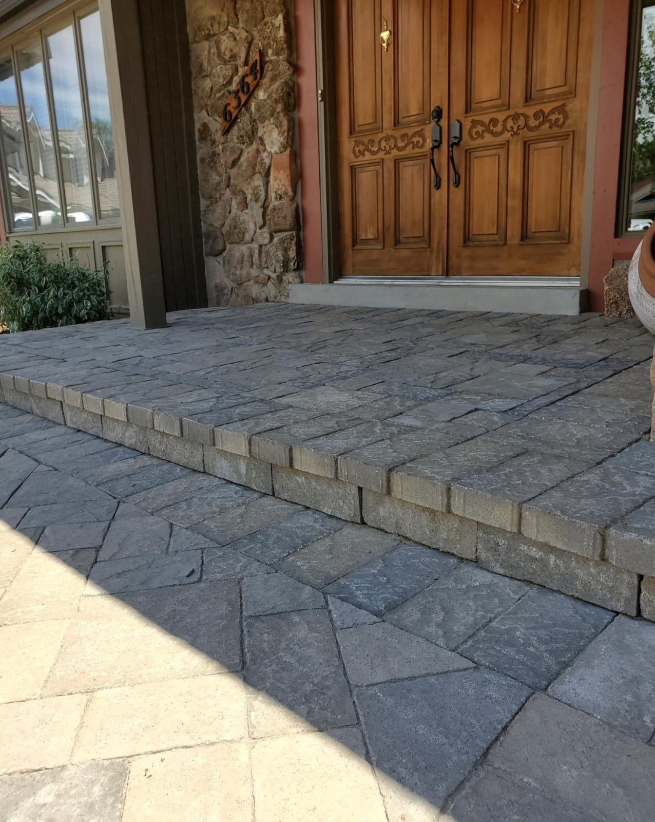 Paver front entry and steps leading to wooden double doors