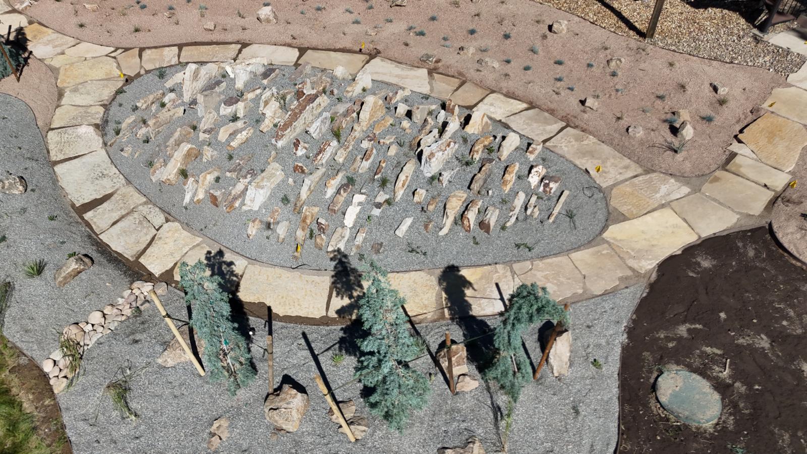 Flagstone path circling a rock garden on a hillside property